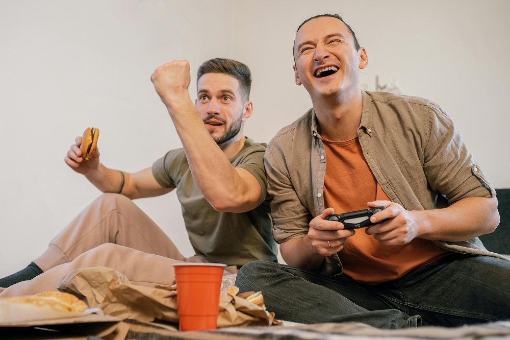 Two roommates playing video games in co-living apartment