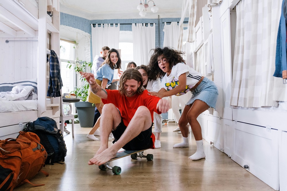 Roommates playing games in co-living apartment bedroom (Source: pexels.com)