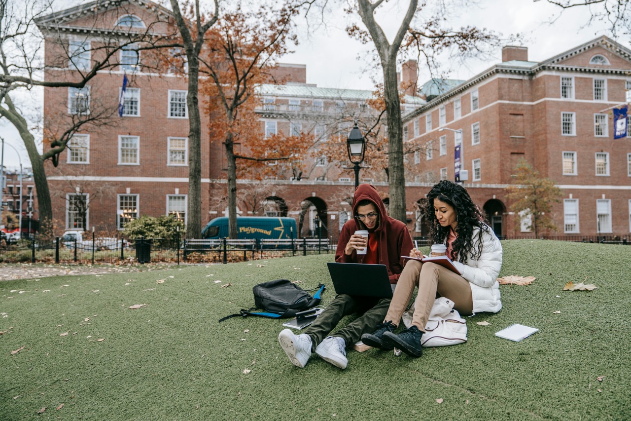 Man and woman studying on the campus lawn
